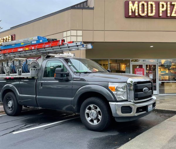 grey work truck in front of Mod Pizza